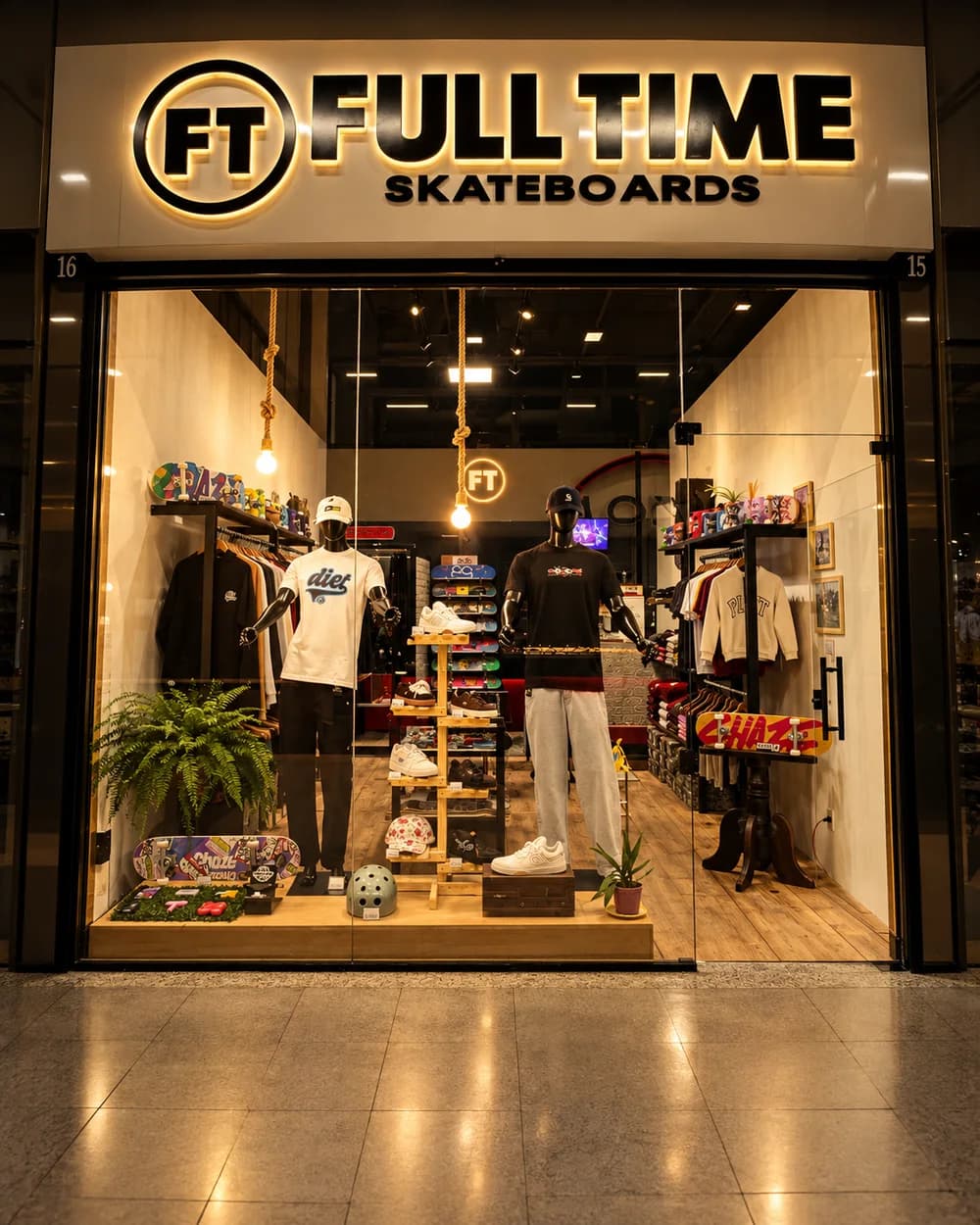 A fachada da Full Time Skateboards na Galeria Xaxim, com o letreiro aceso e a vitrine iluminada